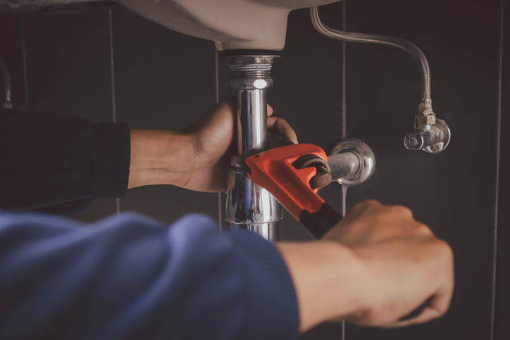 plumber at work in a bathroom, plumbing repair service