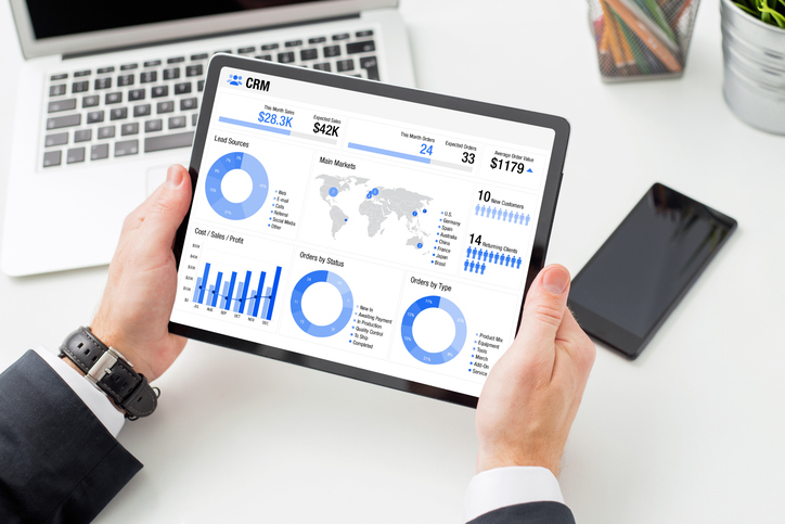 Man examining infographics on the tablet computer indicating different business data