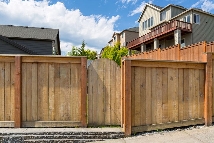 House backyard new wood fence garden gate door in suburban residential neighborhood