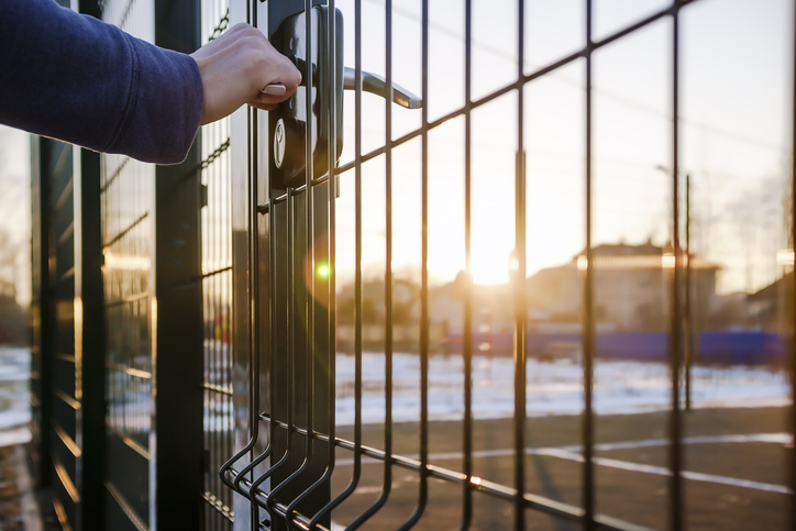 person wants get in on playground through the little gate of the welded wire mesh, wonderful winter sunny day