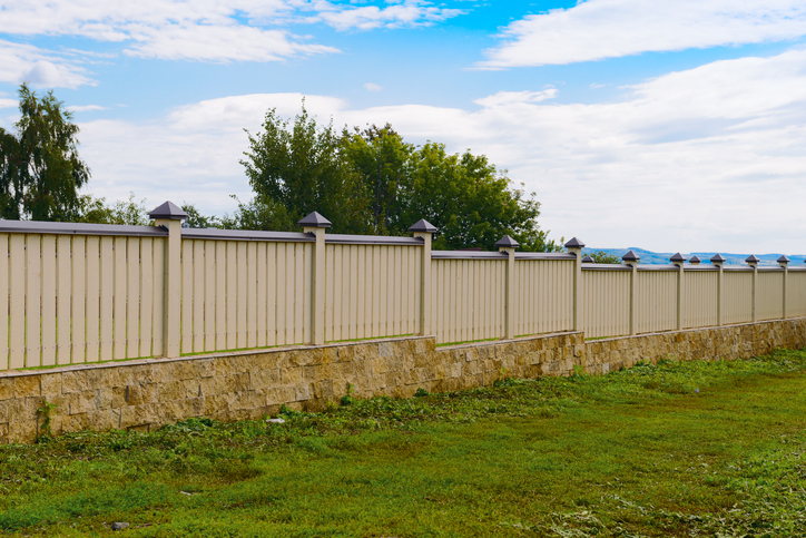 advantages of installing a privacy fence wooden fence painted yellow with a stone base stock photo 